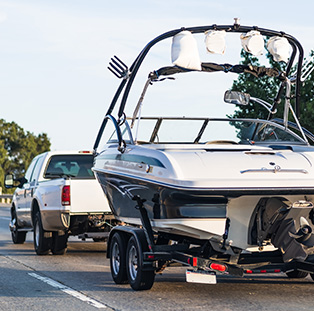 Wake boat trailer being towed behind a truck